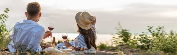 Горизонтальная концепция пары, держащей бокалы с красным вином снаружи — стоковое фото