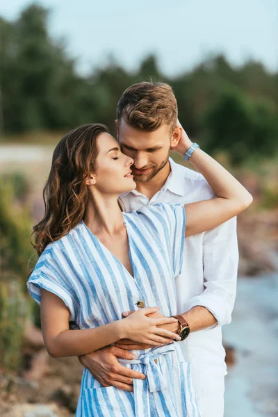 Beautiful woman smiling and hugging bearded man outside — Stock Photo