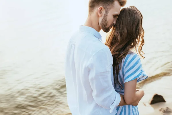 Barbudo hombre abrazando novia cerca de lago - foto de stock