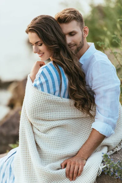 Barbudo homem tocando cobertor enquanto abraçando namorada fora — Fotografia de Stock
