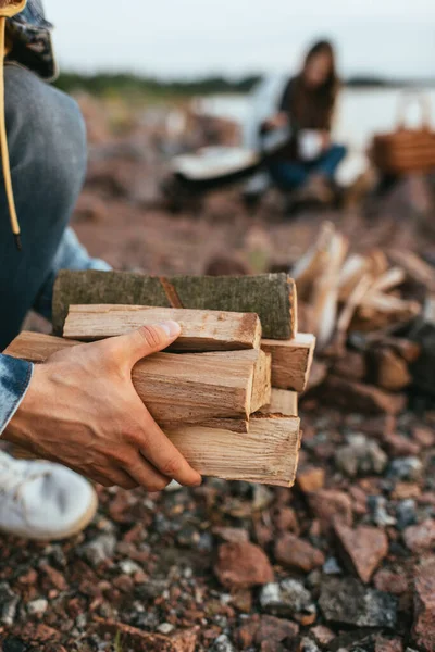 Cropped view of man holding firewood near girl — Stock Photo