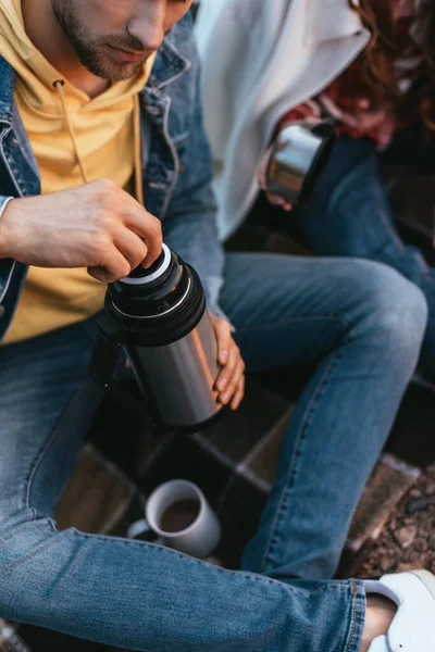 Cropped view of bearded man holding thermos near cup with tea and girl — Stock Photo