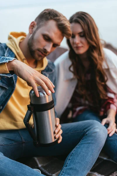Selective focus of bearded man holding thermos beautiful girl — Stock Photo