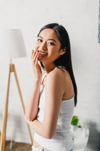 Hermosa mujer asiática sonriendo a la cámara en casa - foto de stock