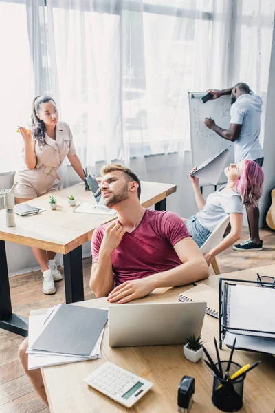 Foco seletivo de empresários multiétnicos esgotados que sofrem de calor no escritório — Fotografia de Stock