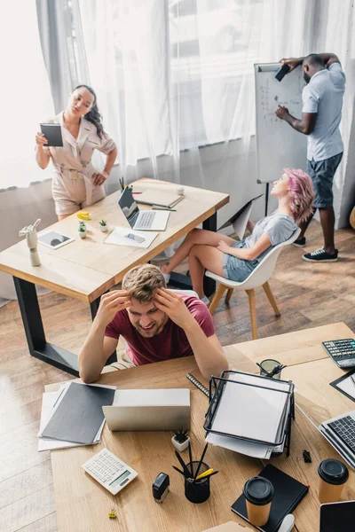 High angle view of exhausted multicultural business people suffering from heat in office — Stock Photo