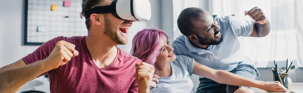 Horizontal crop of multicultural business people showing yeah gesture while using vr headset in office — Stock Photo