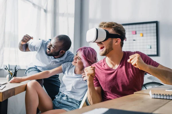 Focus selettivo di uomini d'affari multiculturali che mostrano sì gesto durante l'utilizzo di auricolari vr in ufficio — Foto stock