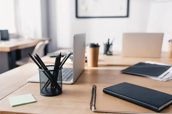 Focus selettivo di notebook, cancelleria e laptop su tavolo in legno in ufficio — Foto stock