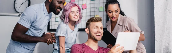 Horizontal crop of multicultural business people using digital tablet in office — Stock Photo