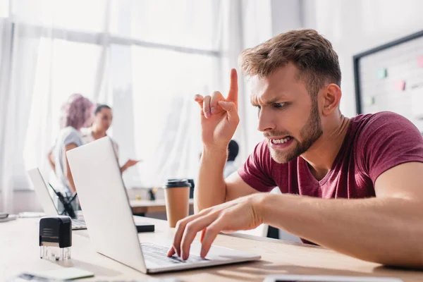 Selektiver Fokus des konzentrierten Geschäftsmannes, der eine Idee hat, während er Laptop im Büro benutzt — Stockfoto