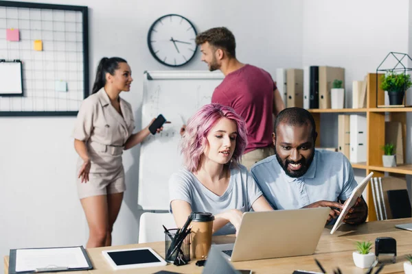 Enfoque selectivo del empresario afroamericano sosteniendo tableta digital cerca de colega - foto de stock