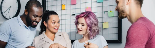 Panoramic crop of young multiethnic business people working in office — Stock Photo