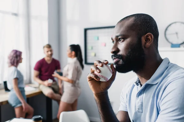 Selektiver Fokus des nachdenklichen afrikanisch-amerikanischen Geschäftsmannes mit Baseballball im Amt — Stockfoto