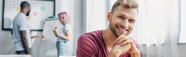 Raccolto orizzontale di giovane uomo d'affari guardando la fotocamera in ufficio — Foto stock