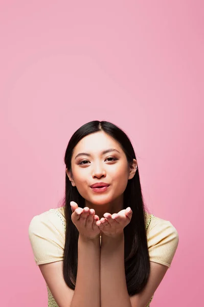 Junge asiatische Frau Senden Luftkuss und Blick auf Kamera isoliert auf rosa — Stockfoto