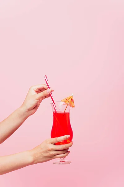 Cropped view of young woman holding glass with cocktail isolated on pink — Stock Photo