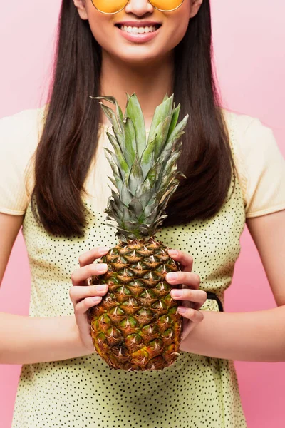 Vue recadrée de fille heureuse tenant ananas frais isolé sur rose — Photo de stock