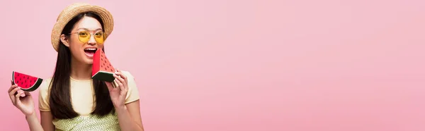 Imagem horizontal de feliz mulher asiática com boca aberta segurando papel fatiado melancia isolado em rosa — Fotografia de Stock