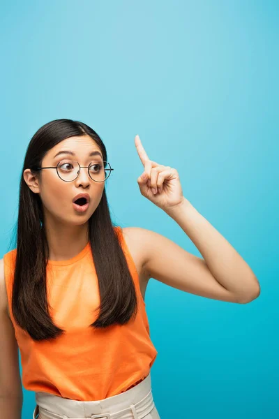 Asiatische junge Frau in Brille mit Idee auf blau — Stockfoto