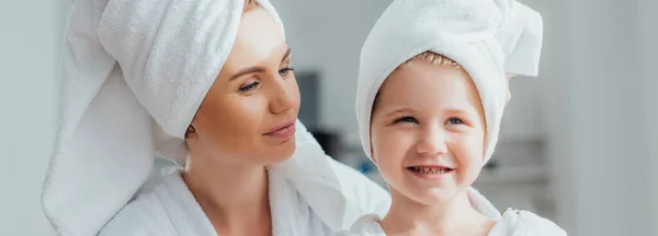 Imagem horizontal de jovem mãe e filha com toalhas na cabeça em casa — Fotografia de Stock