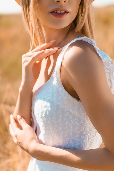Recortado vista de sensual joven mujer en verano traje tocando cuello en sol - foto de stock