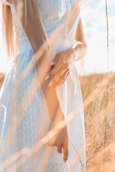 Cropped view of woman in white dress standing in grassland, selective focus — Stock Photo