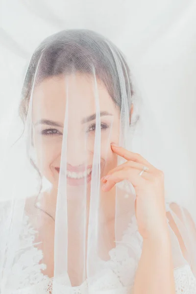 Bride in veil looking at camera on white background — Stock Photo