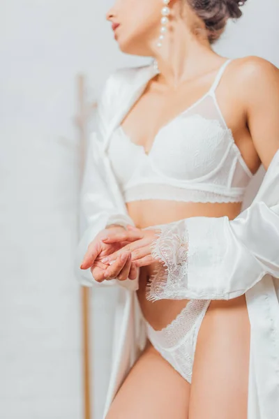 Vista cortada da jovem noiva vestindo lingerie e robe de seda em casa — Fotografia de Stock