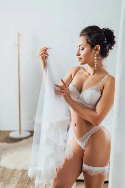 Mariée sexy en dentelle lingerie toucher voile à la maison — Photo de stock