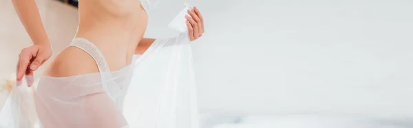 Панорамна орієнтація нареченої в нижній білизні, що тримає білу фату вдома — стокове фото