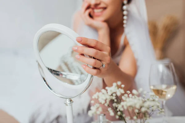 Vue recadrée de la mariée touchant miroir près des fleurs et verre sur le vin — Photo de stock