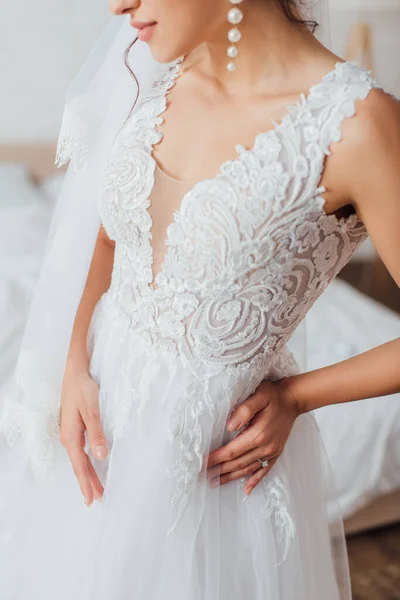Обрізаний вид на наречену в фаті і мереживне весільне плаття вдома — стокове фото
