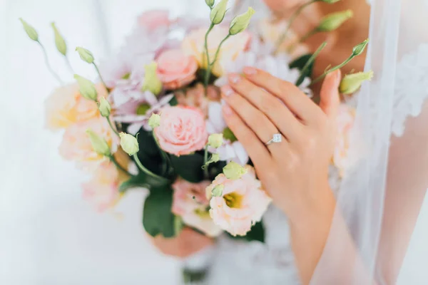 Vue recadrée de la mariée avec bague à bijoux sur doigt touchant des fleurs dans le bouquet — Photo de stock