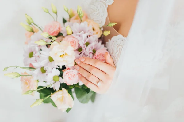 Vista cortada da noiva em vestido de noiva e véu segurando buquê floral — Fotografia de Stock