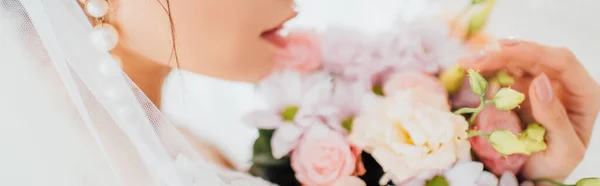 Plan panoramique de mariée en boucle d'oreille perle et voile touchant bouquet — Photo de stock