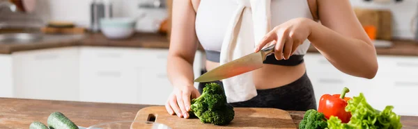 Encabezado del sitio web de la mujer de corte de brócoli en la tabla de cortar - foto de stock