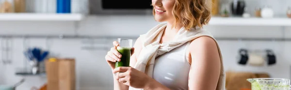 Panoramic image of young woman holding glass of green smoothie — Stock Photo