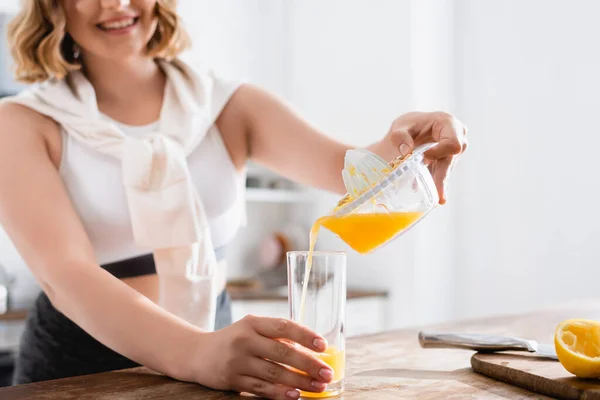 Vista ritagliata della donna versando succo d'arancia fresco in vetro — Foto stock