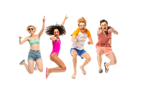 Excited multiethnic friends in sunglasses and flip flops jumping isolated on white — Stock Photo