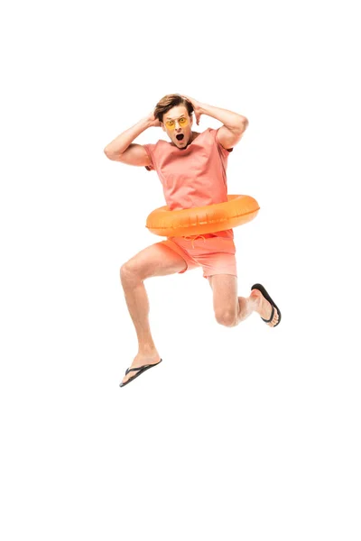 Hombre sorprendido en gafas de sol y anillo de natación saltando aislado en blanco - foto de stock