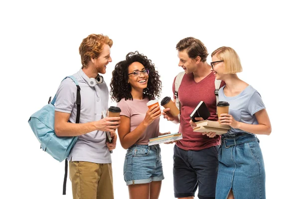 Estudiantes con café para ir mirando a un amigo afroamericano con libros aislados en blanco - foto de stock