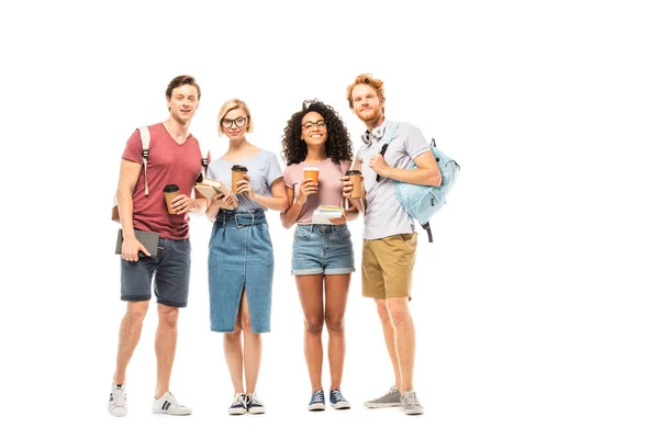 Étudiants multiethniques avec café à emporter et livres regardant la caméra sur fond blanc — Photo de stock