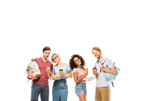 Estudiantes multiétnicos con café para llevar, libros y teléfonos inteligentes aislados en blanco - foto de stock