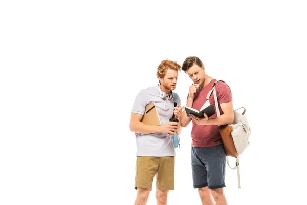 Étudiants pensifs avec tasse jetable et sacs à dos regardant ordinateur portable isolé sur blanc — Photo de stock