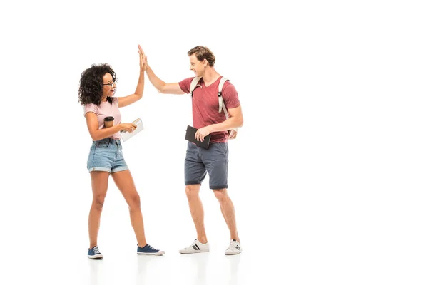 Student with backpack giving high five to african american friend on white background — Stock Photo