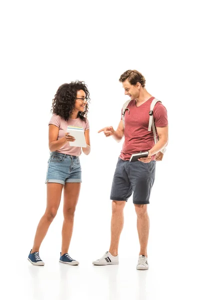 Student pointing with finger at book near african american friend on white background — Stock Photo