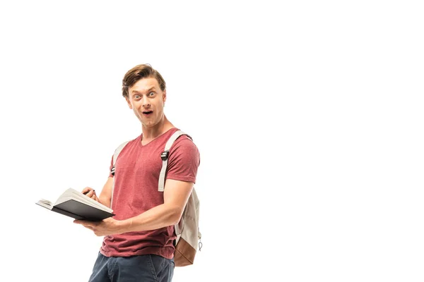 Shocked student holding notebook and looking at camera isolated on white — Stock Photo