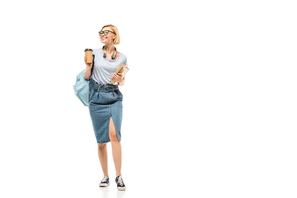 Student in headphones holding coffee to go and books on white background — Stock Photo