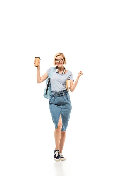 Student with books and coffee to go showing yeah gesture on white background — Stock Photo